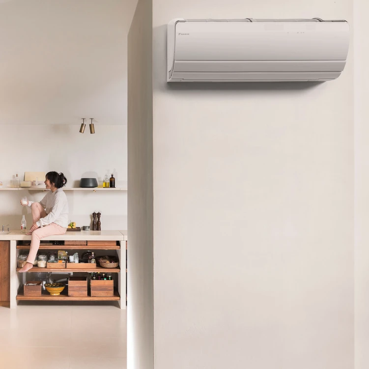 a woman sitting on a counter with a white air conditioner