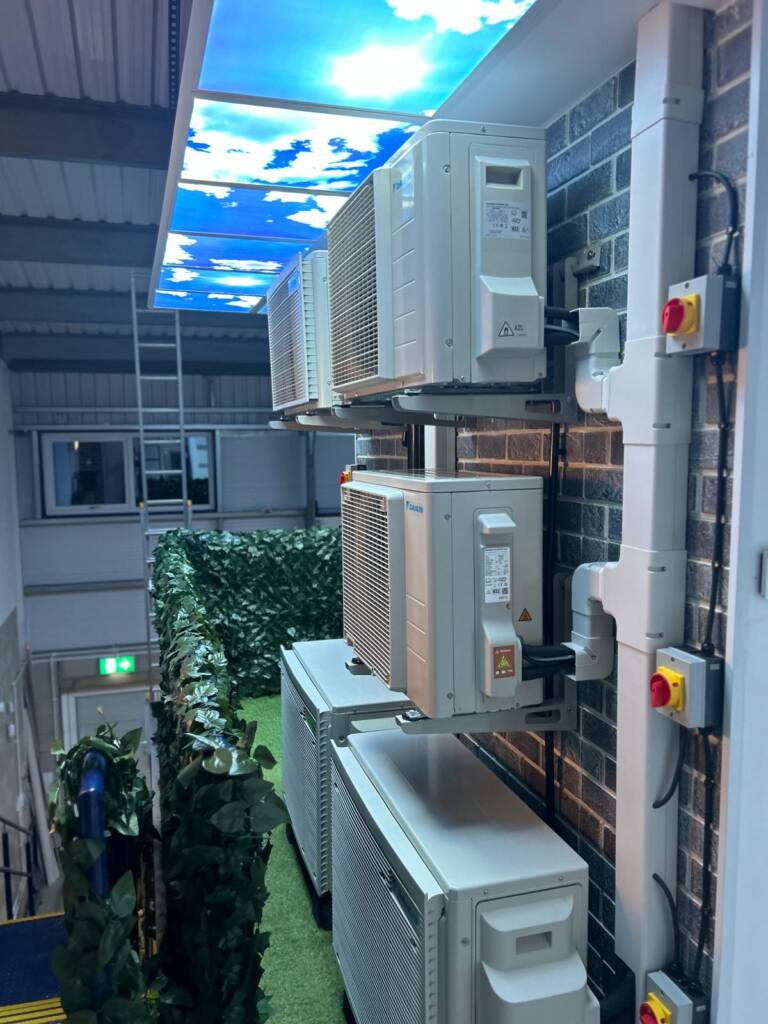 a group of air conditioners on a brick wall