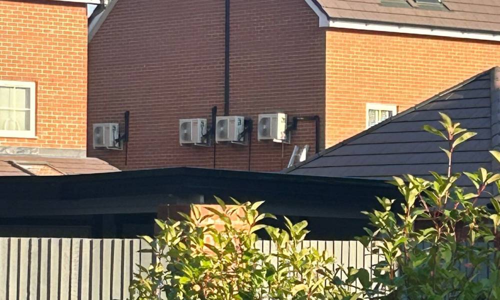 a group of houses with trees and a fence